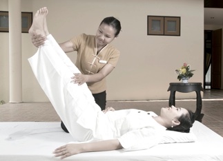 Woman getting Thai massage from professional masseuse